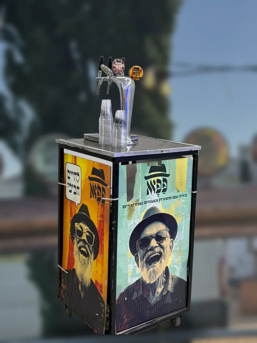 עגלת הבירות של פפא עם שלושה ברזים וכרזות של הגיבורים, בגן